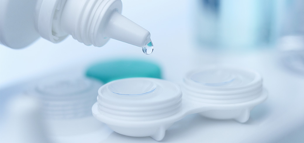 An image of contact lens solution being added to a lens case.