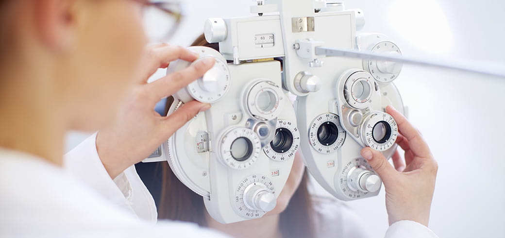 Image of an optician setting up eye test apparatus.